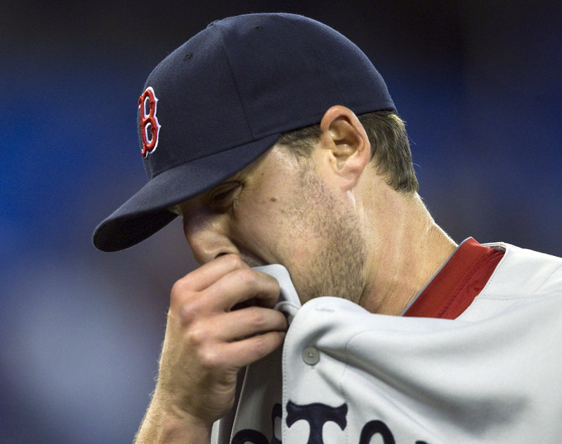 John Lackey of the Boston Red Sox walks off the field Wednesday night after being pulled from the game in the seventh inning of a 9-3 loss to the Toronto Blue Jays.