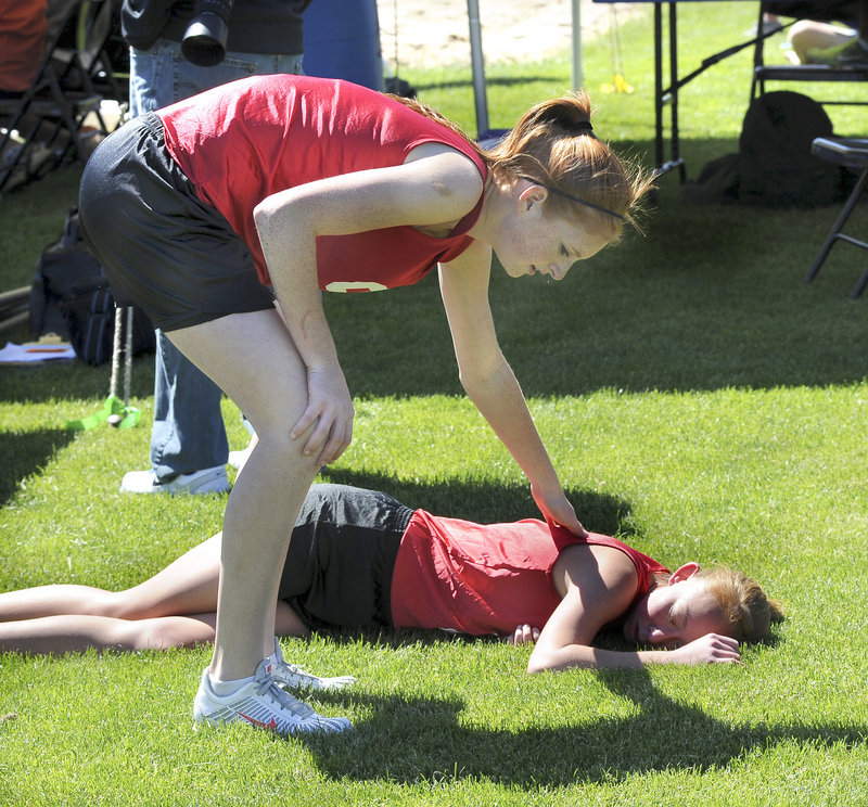 Hannah Kalis checks on Sanford teammate Jill Porter after their 4x800 relay. They teamed with Jacque Farmer and Amanda Beaulieu to place seventh.