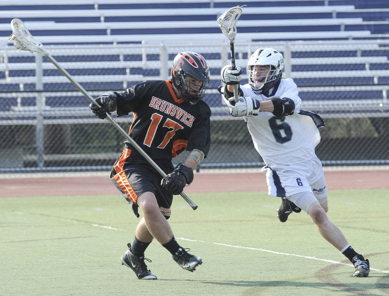 Portland’s Seamus Kilbride goes after the ball and Brunswick’s Dana Merrill during their playoff game Wednesday at Fitzpatrick Stadium.