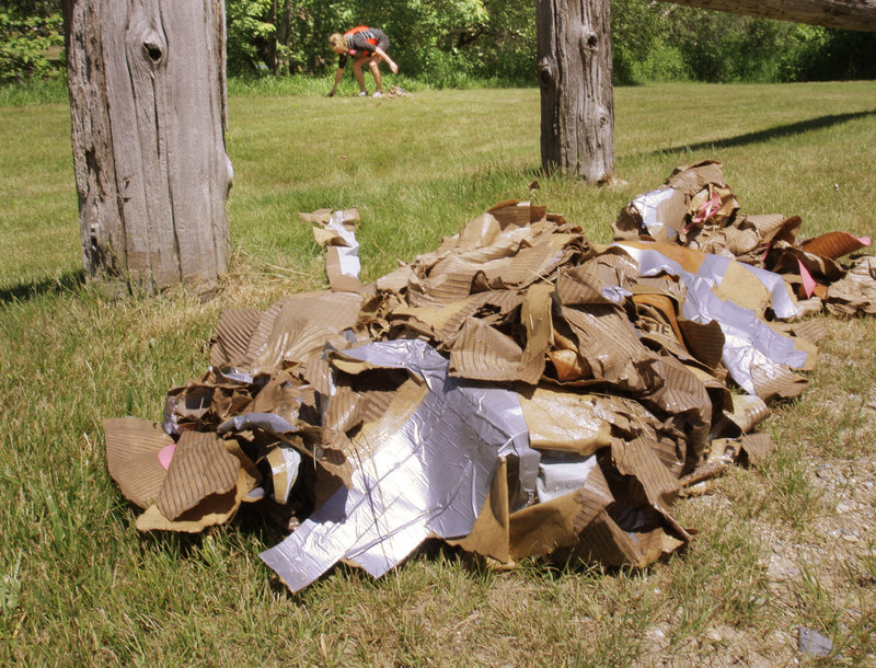 Bryan gathers the soggy remains of her vessel after it foundered in the Saco River.