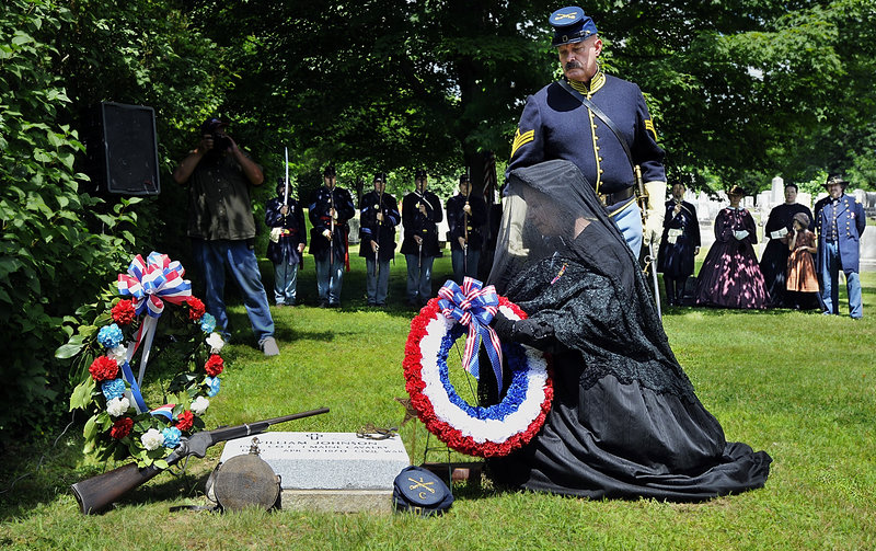 Carolyn Lawson, a member of the Auxiliary to the Sons of Union Veterans of the Civil War, lays a wreath at a new headstone marking the grave of Civil War Pvt. William Johnson, with the assistance of Mike Nugent of the 1st Cavalry re-enactors. At rear are the 3rd Maine Infantry re-enactors and character re-enactors of the Civil War era.