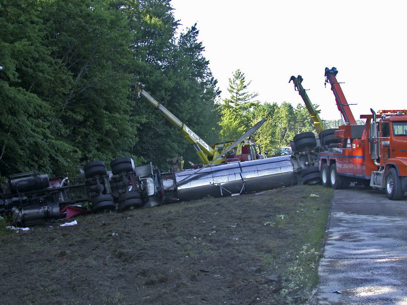 Traffic is detoured as wreckers work to right a tanker truck that skidded sideways to avoid a collision and rolled over into a ditch on Route 111 at Spruce Street in Lebanon on Friday. Ambulances transported two people to H.D. Goodall Hospital in Sanford with non-life-threatening injuries.