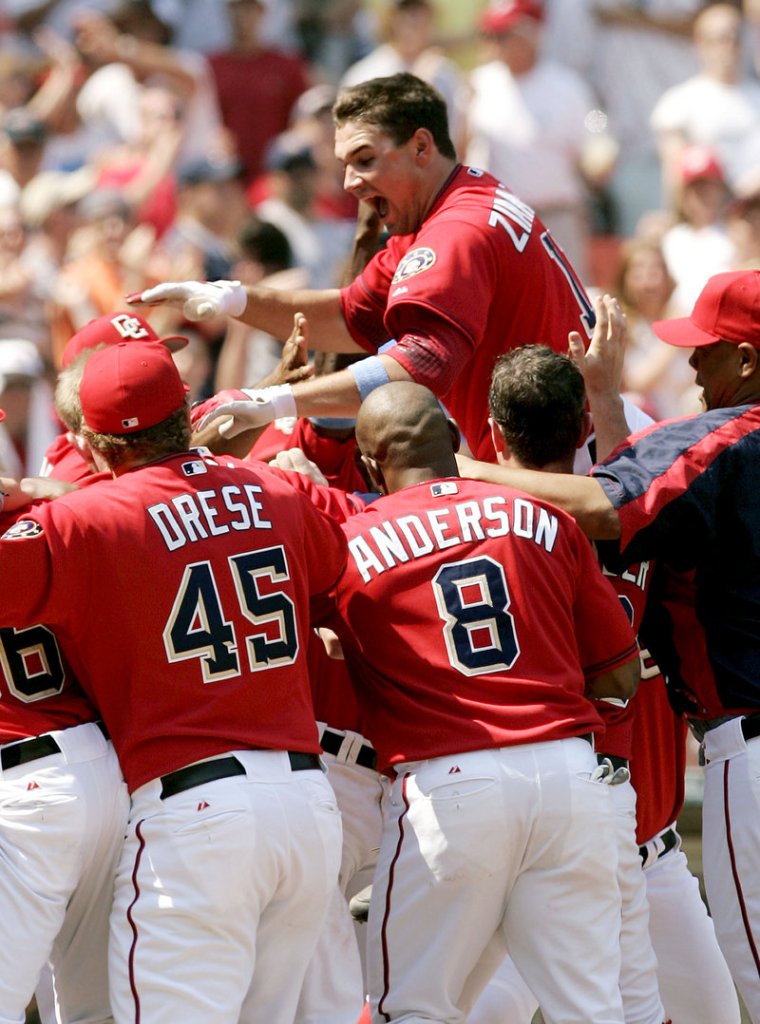 The Washington Nationals’ Ryan Zimmerman leaps onto home plate after hitting a game-winning home run against the New York Yankees on June 18, 2006.