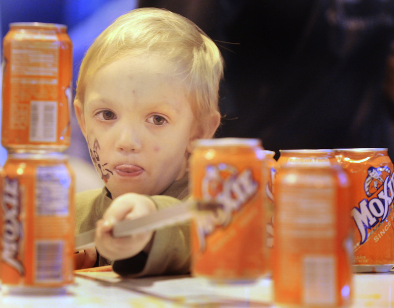 Jeremiah Lawrence, 4, of South Paris, concentrates on stacking weighted Moxie cans today in a game in the children's area at the Baxter School's gymnasium during Maine's Deaf Culture Festival on Mackworth Island in Falmouth.