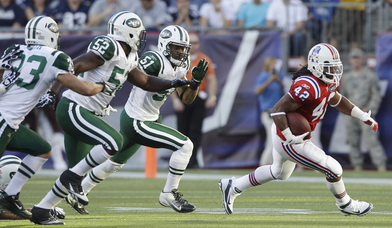 New England’s BenJarvus Green-Ellis draws the attention of New York’s defense in the first quarter Sunday at Gillette Stadium in Foxborough, Mass. Green-Ellis ran 27 times for a career-high 136 yards and two touchdowns as New England beat its fiercest rival.