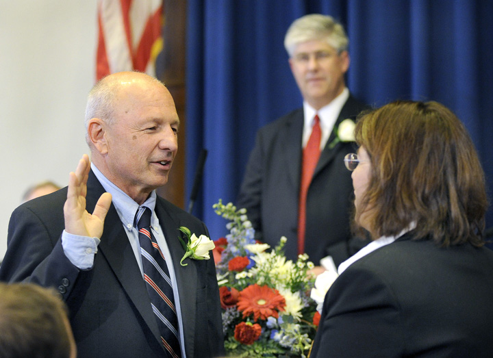 Michael F. Brennan is sworn in by Portland City Clerk Katherine Jones in council chambers at Portland City Hall today as the first popularly elected Portland mayor in more than 88 years. Outgoing Mayor Nicholas M. Mavodones Jr. stands in the background.