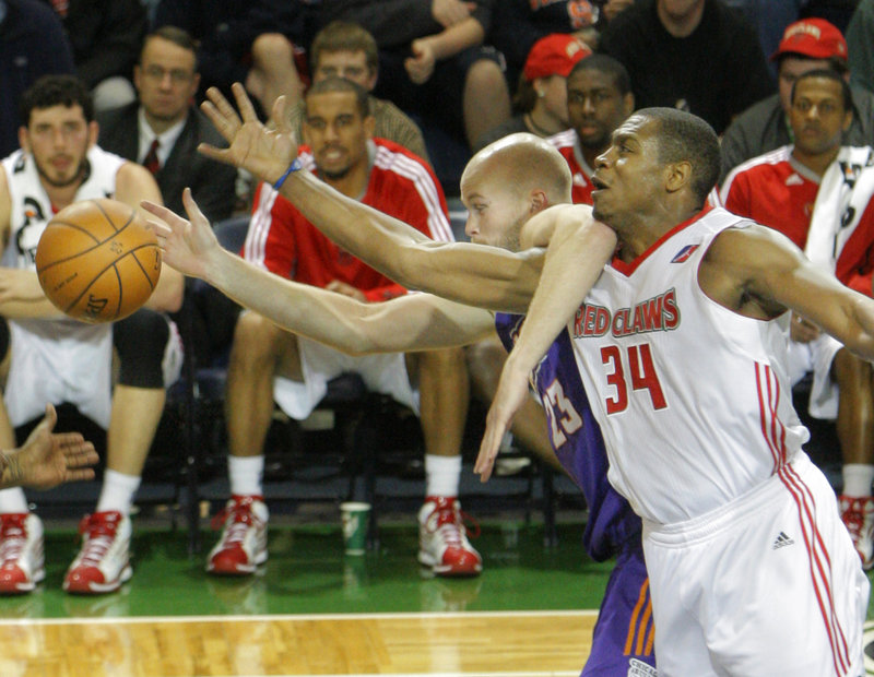 Justin Brownlee of the Maine Red Claws, 34, and Michael Tveidt of the Iowa Energy get tangled up while competing for a loose ball Friday night. The Red Claws held a 21-point lead midway through the third quarter, then lost.