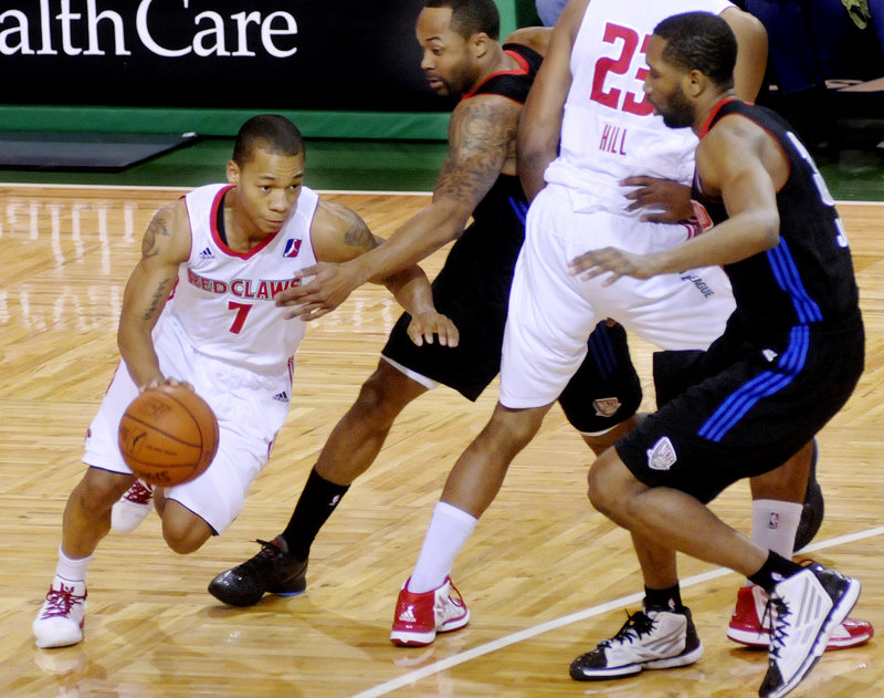 Jerome Randle of the Red Claws uses a pick to drive past Springfield’s Jerry Smith on his way to the basket Sunday at the Portland Expo.