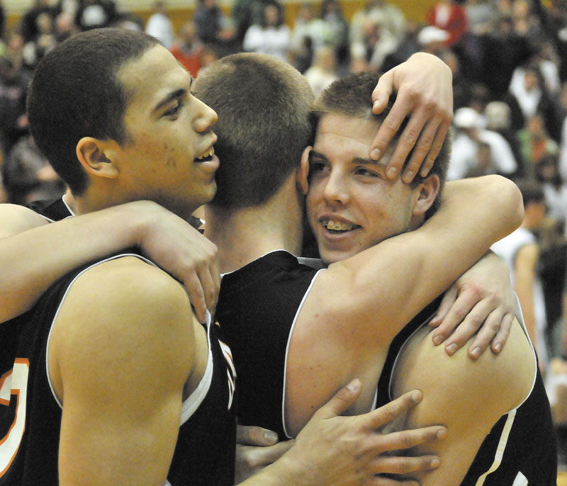 Gardiner’s Matt Hall, right, hugs a teammate while Alonzo Connor, left, also celebrates after the Tigers beat Mt. Desert Island 70-58 in the Eastern Class B final at the Bangor Auditorium.