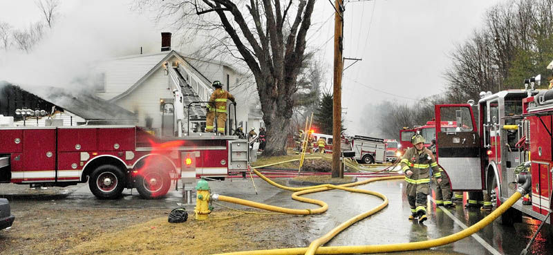 Firefighters work at the scene of a fire in a four-unit apartment building at 208 Hospital St. in Augusta on Friday.