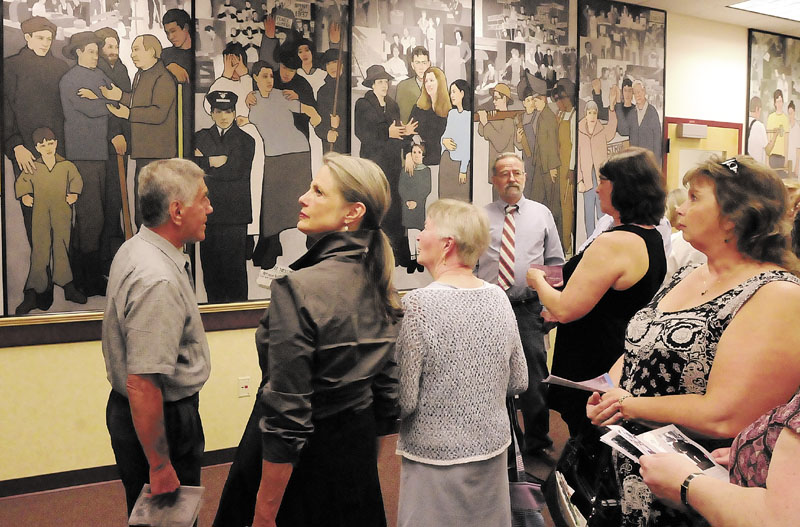 Interested Mainers study a mural by Judy Taylor depicting the history of labor in Maine. A judge ruled Friday that Gov. Paul LePage had a right to remove the mural. LePage's actions created a controversy in Maine.