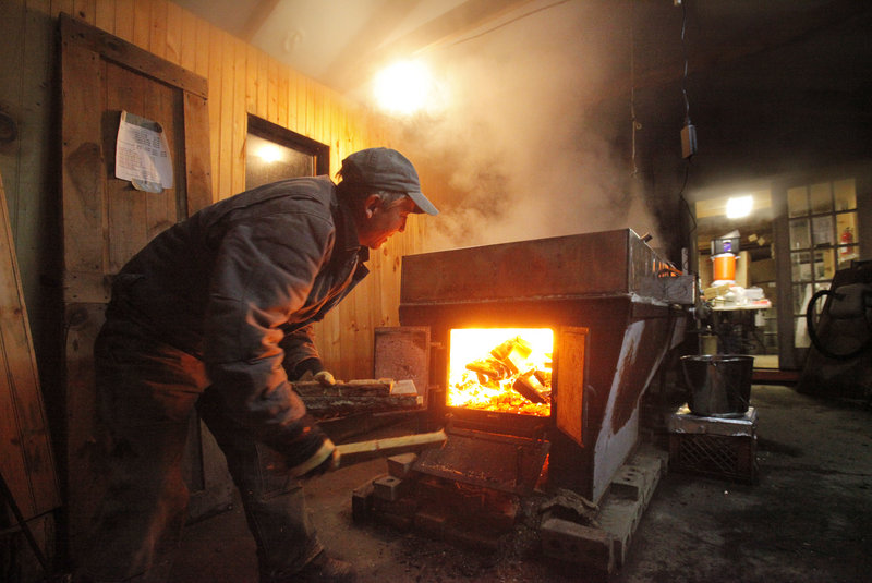 Cooper stokes the fire while boiling sap.