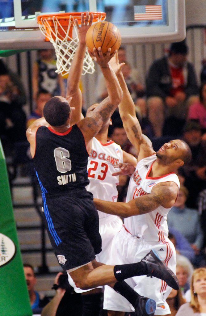 Lawrence Hill, center, and Xavier Silas of the Red Claws try to block a shot by Springfield’s Jerry Smith during Sunday’s game at the Portland Expo. Maine rallied for a 110-101 overtime victory.