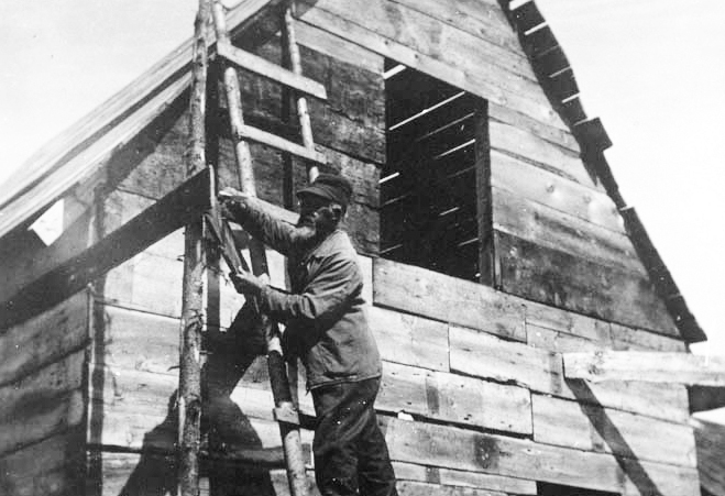 John Eason repairs a building on Malaga Island in 1908.