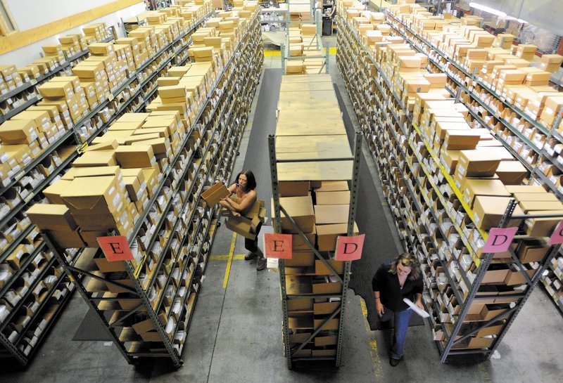 Workers at Johnny’s Selected Seeds in Winslow sort packages at the shipping center. The company reports strong growth and has created four new positions.