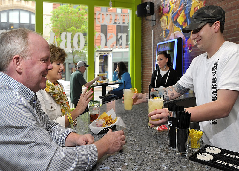 Bartender Eric Kreidler delivers margaritas to Doug and DeeDee Norton of Scarborough at Taco Escobarr, 548 Congress St., Portland.