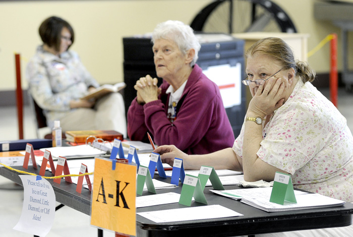 Election clerks Christine Thibeault, left, Jane Chesebro and Julia Haigh pass the time at Portland's Ward 1, Precinct 2 polling place at Merrill Auditorium this morning. As of 10 a.m. they had recorded only 30 voters.