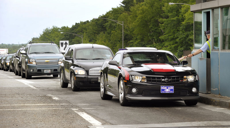 Ron Legere, above and below, collects tolls at the Falmouth spur, Exit 52 of the Maine Turnpike, as motorists leave the highway Tuesday.