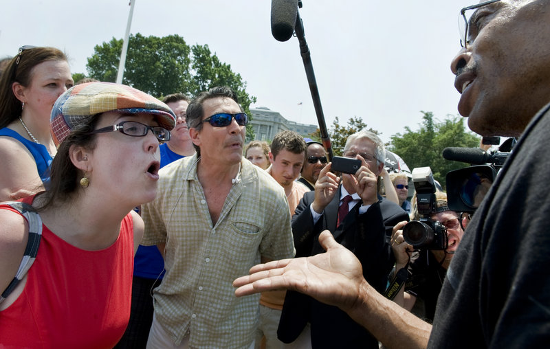 Opponents of President Obama’s health care plan, tea party activists Jenny Beth Martin of Atlanta, rear left, Keli Carender of Seattle and David Walls-Kaufman of Washington, get in a heated discussion with health care supporter Michael Paysour of Washington in front of the Supreme Court after the ruling on the Affordable Care Act was announced upholding most of the plan.