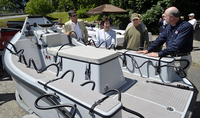 Sen. Susan Collins looks over the rescue craft with Tim Hodgdon, left, owner of Hodgdon Yachts, David Packhem, right, CEO and president of Hodgdon Defense Composites, and boat designer Peter Maguire. The boat has a water jet-driven engine and a composite hull.