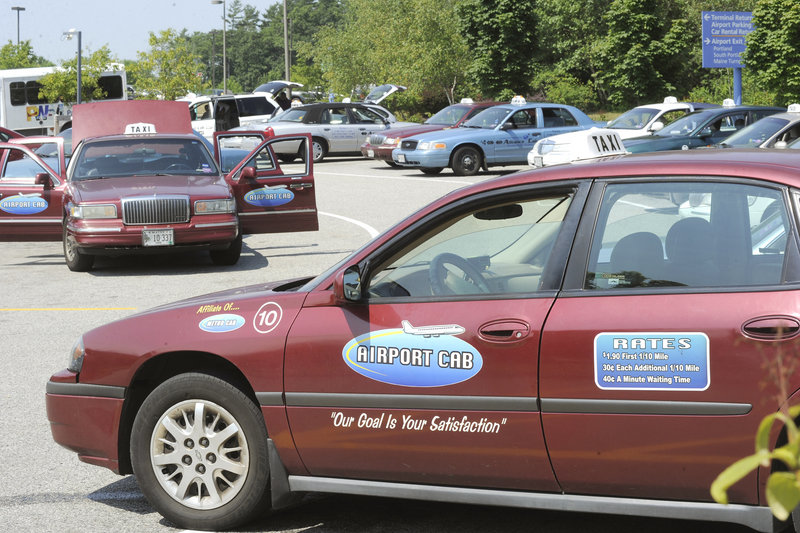 Taxis wait their turn in a parking lot to pick up fares at the Portland International Jetport on Friday.