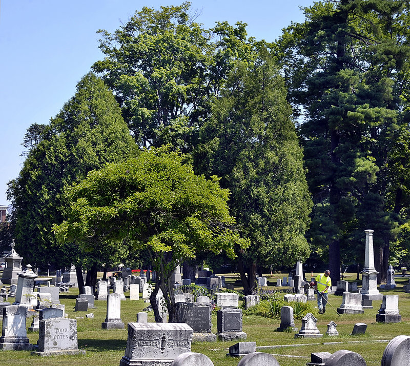 A maintenance worker tends the grounds in Evergreen Cemetery in Portland. The city’s use of an endowment trust for two other cemeteries has come under scrutiny.