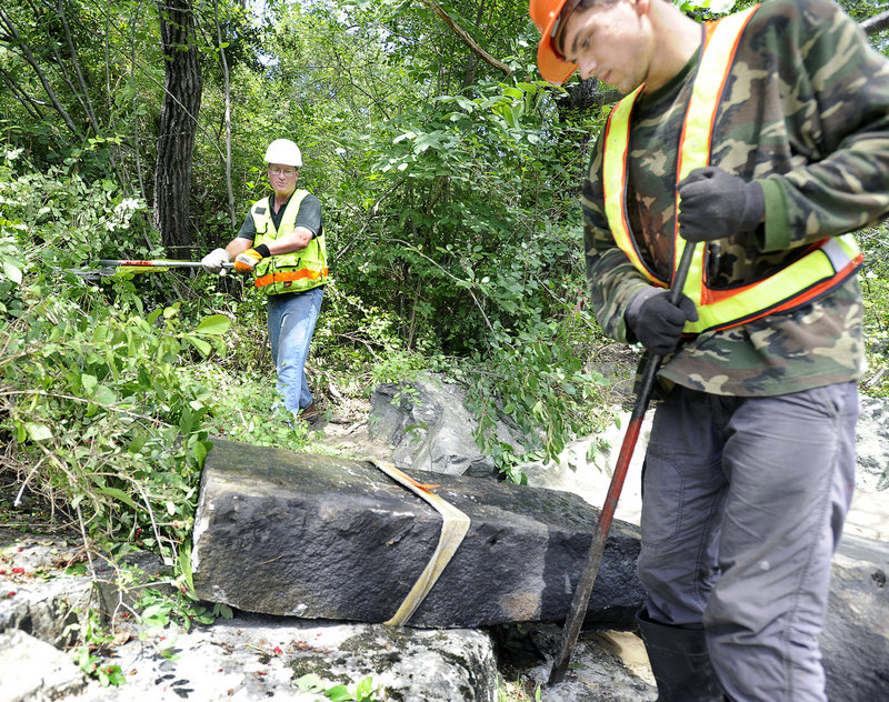 Jed Wright, left, from U.S. Fish & Wildlife, works a winch as Cecil Cates uses a crowbar during the restoration project Tuesday on the Royal River. The $5,000 project is funded largely by a grant from the Casco Bay Estuary Partnership, an agency that works to restore fish passages in the bay’s vast watershed area.