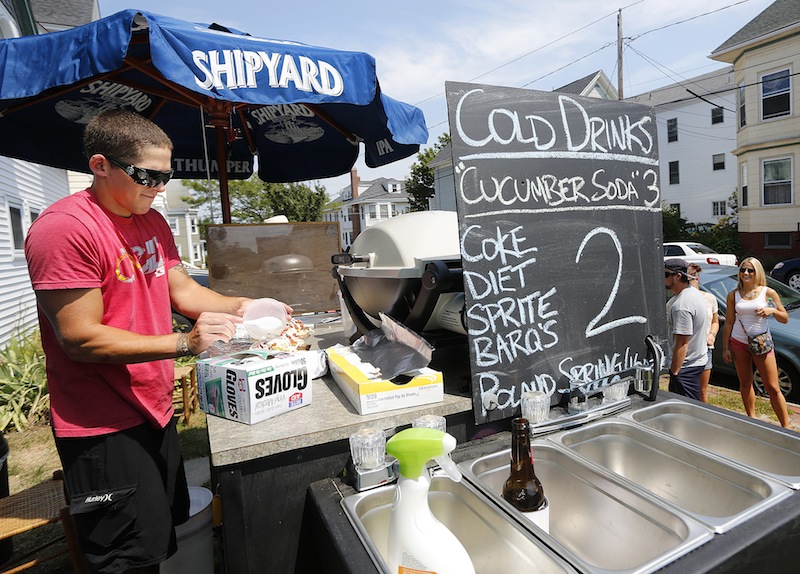 Eliot Poirier makes some Gyros for customers from his food cart on the corner of Vesper Street and Moody Street on Munjoy Hill in Portland near the "Gentleman of the Road Stopover" concert on Saturday, Aug. 4, 2012.