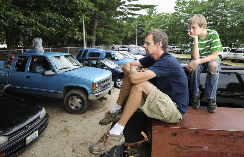 Perched atop a pickup truck to get an elevated view, Matt Hodgdon of Scarborough and his son Josh, 10, watch Saturday stock car racing over the fence of the Beech Ridge Motor Speedway.