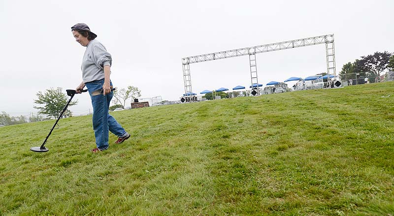 Carol Whitmore of Portland searches the ground with a medal detector on the Eastern Prom Sunday morning, the day after the Mumford & Sons concert.