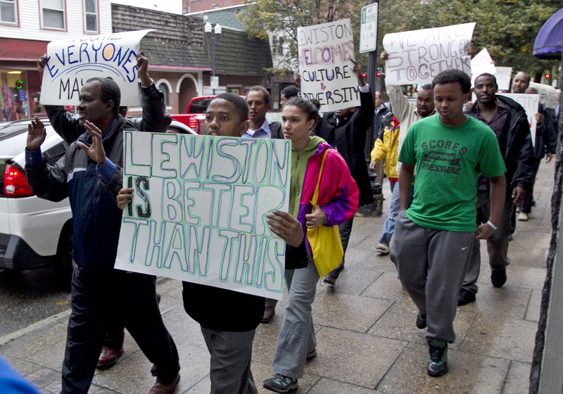 Protesters march in Lewiston on Thursday after delivering petitions to City Hall calling for the mayor to resign following comments he made about immigrants.