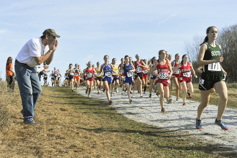 A spectator provides some words of encouragement for Kristen Glennie of Bonny Eagle as she begins her move up in the pack during the Class A girls’ race Saturday in Belfast.