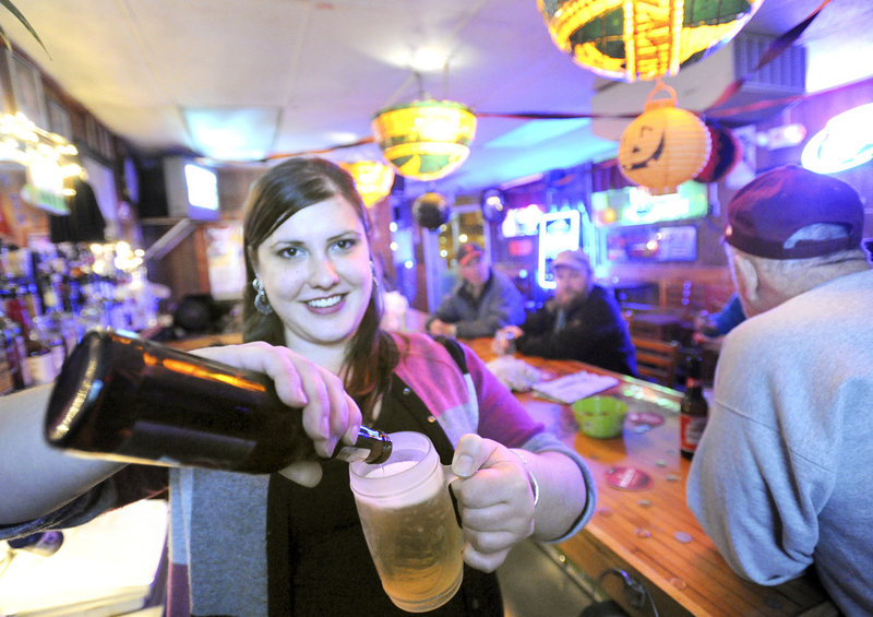 Bartender Clare Finin pours a beer into a frosty mug at Sangillo’s Tavern, a small, friendly bar with affordable prices in the India Street neighborhood of Portland.