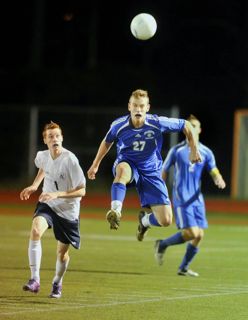 Falmouth’s Hugh Grygiel heads the ball upfield ahead of Yarmouth’s Brendan Dioli on Wednesday night in Yarmouth.