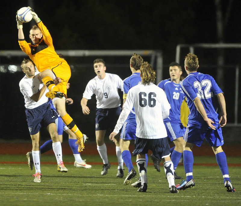 Falmouth goalie Will D’Agostino pulls down a high shot in heavy traffic in front of his goal against Yarmouth.