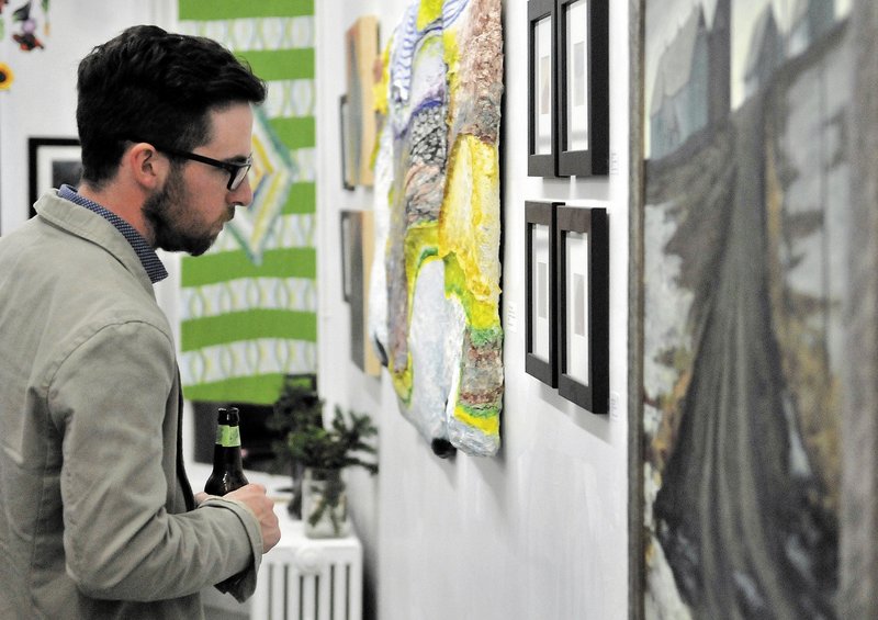 Zach Vickers of Coopers Mills looks at artwork at Common Street Arts in Waterville on Saturday during the opening of an exhibit featuring art inspired by local farms.