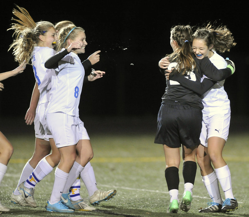 Falmouth goalie Caroline Lucas, black shirt, gets hugs all around from her Falmouth teammates after they secured the Class B title.