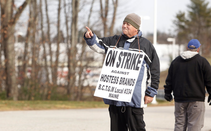 Hernan Descart points to a car carrying two supervisors away from the Hostess plant on Friday. Descart, of South Portland, worked at the plant for eight years.