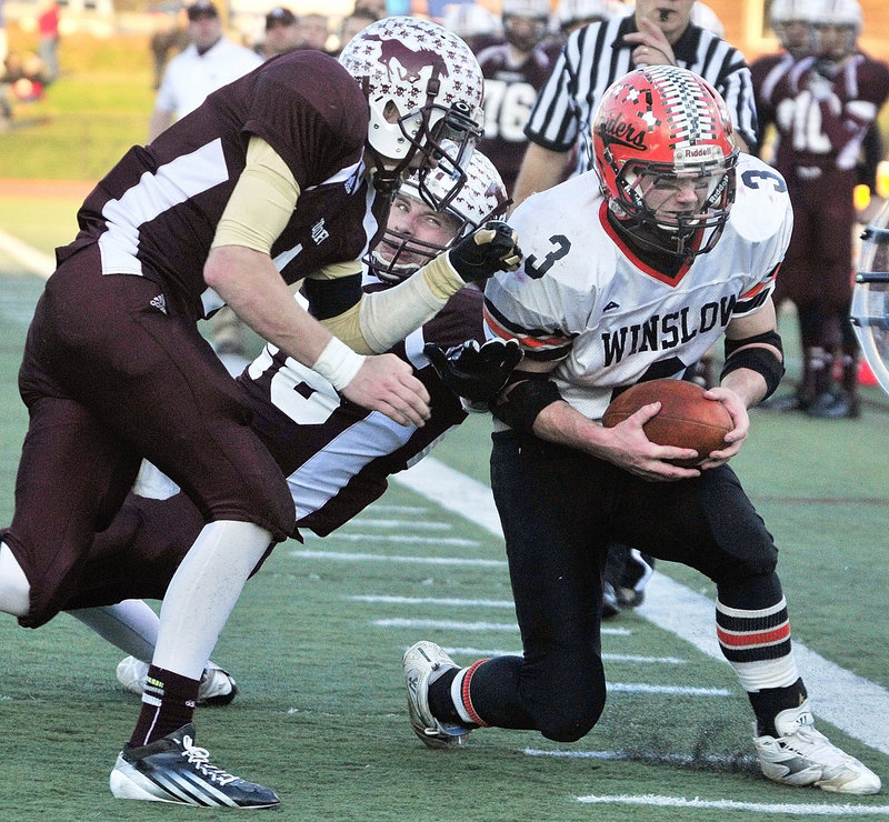 Hunter Law, left, and Ryan Wang of Foxcroft Academy combine to knock Dylan Hapworth of Winslow out of bounds, Foxcroft won its first state championship since 2007.