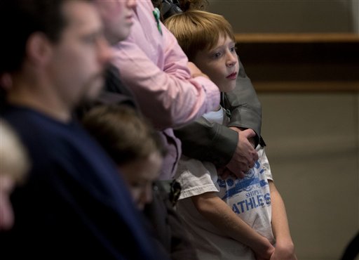 Residents look on during an interfaith vigil for the victims of the Sandy Hook Elementary School shooting on Sunday at Newtown High School in Newtown, Conn.