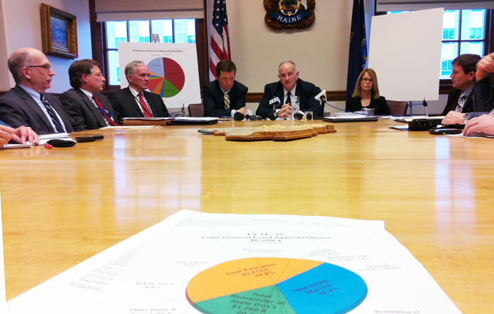 Gov. Paul LePage's budget officer Sawin Millett, center, briefs members of the news media on the governor's $6.2 billion budget proposal. DHHS commissioner Mary Mayhew and education chief Steve Bowen are on the right.