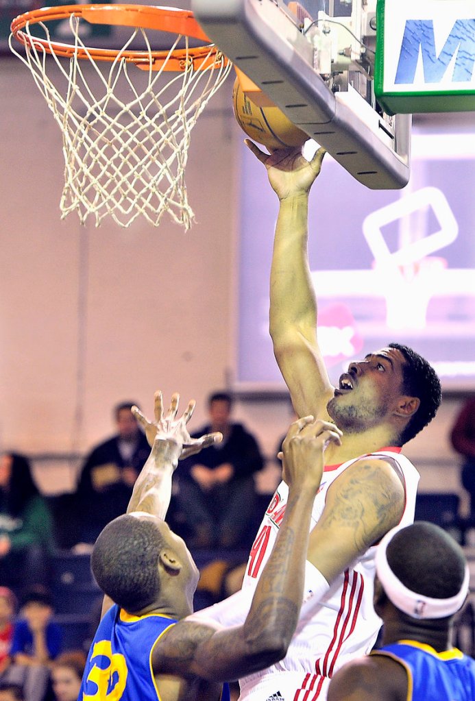 Maine’s Fab Melo scores two of his only four points while Mickell Gladness tries to defend.