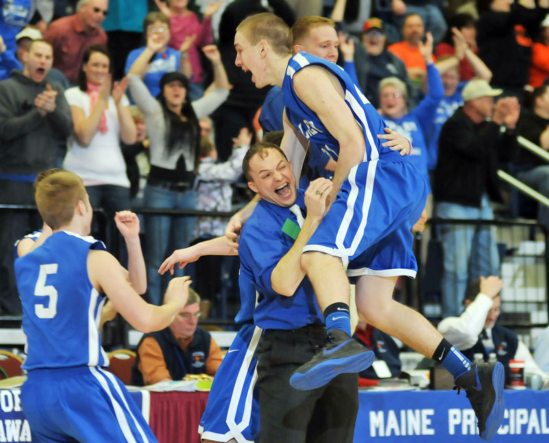 Carrington Miller leaps into the arms of Coach Wade Morrill after his free throws gave Valley a 55-53 win over Hyde in a Western Class D semfinal Wednesday in Augusta.