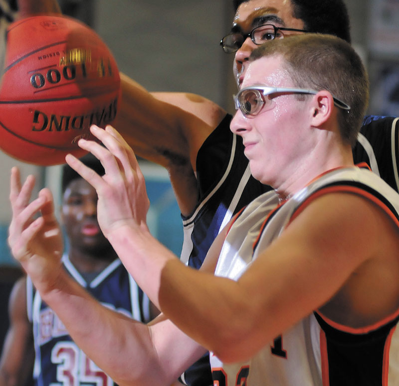 Derick Ouellette of Forest Hills goes up for a basket against A.R, Gould's Isaiah Mokeme in a Western Class D semifinal Wednesday at Augusta. Ouellette scored 32 points to help the Tigers advance to the regional final with a 78-50 victory.