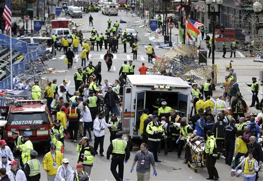 Medical workers aid injured people at the finish line of the 2013 Boston Marathon following an explosion in Boston, Monday, April 15, 2013. Two explosions shattered the euphoria of the Boston Marathon finish line on Monday, sending authorities out on the course to carry off the injured while the stragglers were rerouted away from the smoking site of the blasts. (AP Photo/Charles Krupa)