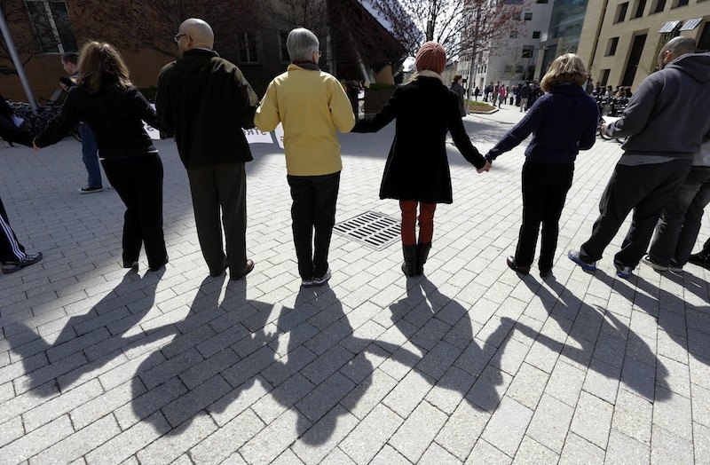 People link hands to form a human chain from a makeshift memorial for fallen MIT police officer Sean Collier to a campus police station at the Massachusetts Institute of Technology in Cambridge, Mass., Monday, April 22, 2013. A moment of silence for victims of the marathon bombings was also observed during the event. Collier was fatally shot on the MIT campus Thursday, April 18, 2013. Authorities allege that Boston Marathon bombing suspects Tamerlan and Dzhokhar Tsarnaev were responsible. (AP Photo/Steven Senne)