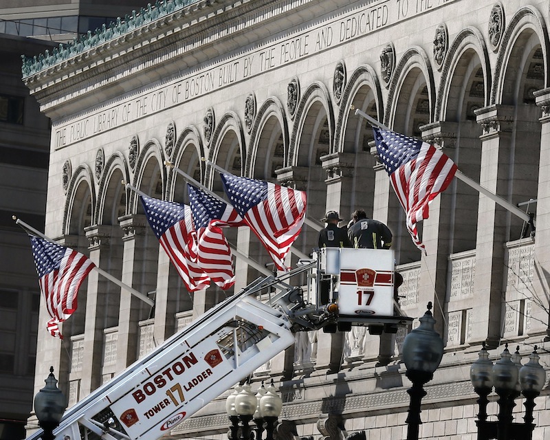 Responders search the area around the Boston Public Library near the finish line of the Boston Marathon with a ladder truck in Boston Tuesday, April 16, 2013. Two bombs blew up seconds apart Monday at the finish line of one of the world's most storied races, tearing off limbs and leaving the streets spattered with blood and strewn with broken glass. At least three people were killed, including an 8-year-old boy, and more than 170 were wounded. (AP Photo/Winslow Townson)