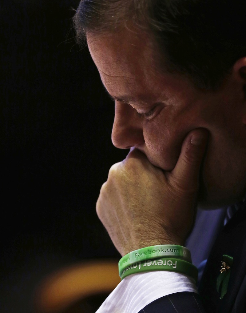 While wearing green wrist bands honoring the victims of the Newtown school shooting, Senate Minority Leader John McKinney, R-Fairfield, who represents Newtown, Conn., looks at his notes prior to addressing the Senate floor at the Capitol in Hartford, Conn., Wednesday, April 3, 2013. Hundreds of gun rights advocates are gathering at the statehouse in Hartford ahead of a vote in the General Assembly on proposed gun-control legislation. (AP Photo/Charles Krupa)