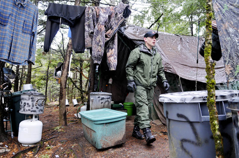 District Game Warden Aaron Cross exits Christopher Knight's camp Tuesday.