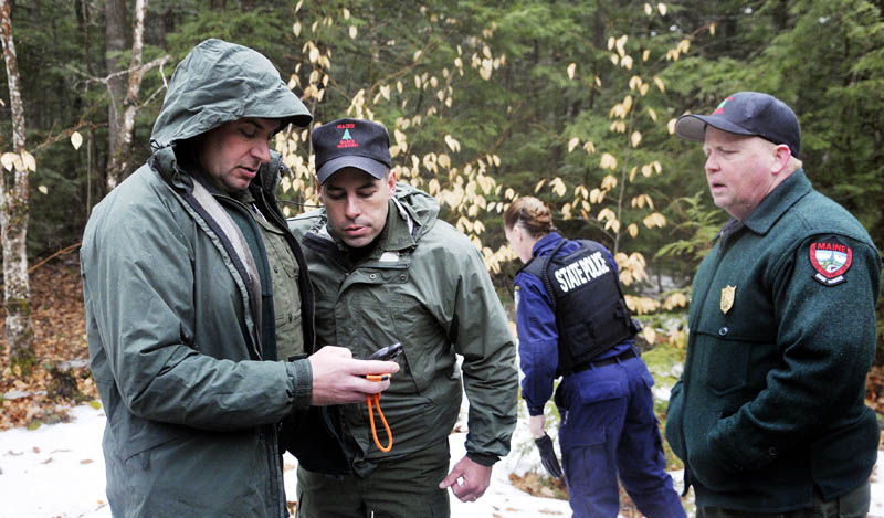 Game wardens and state police retrieve global positioning coordinates before hiking to Christopher Knight's camp in Rome Tuesday.